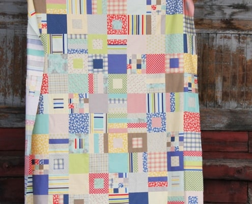A quilt made of different sizes of squares and strips